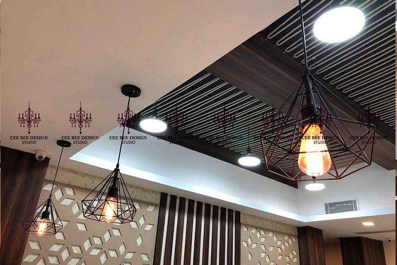 Three modern light fixtures hanging from the ceiling in an office interior design.