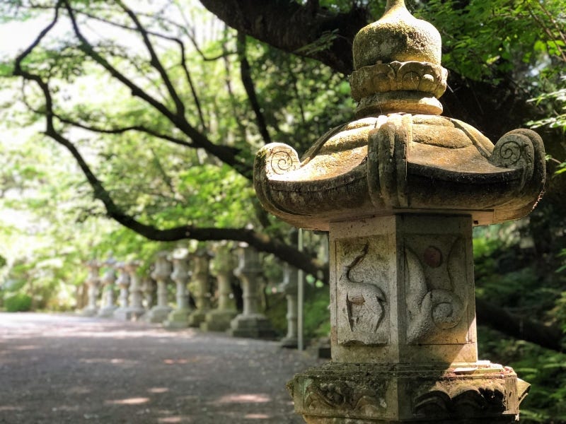 A stone lantern with a deer on it on the approach to Chiba Prefecture’s Katori Jingu