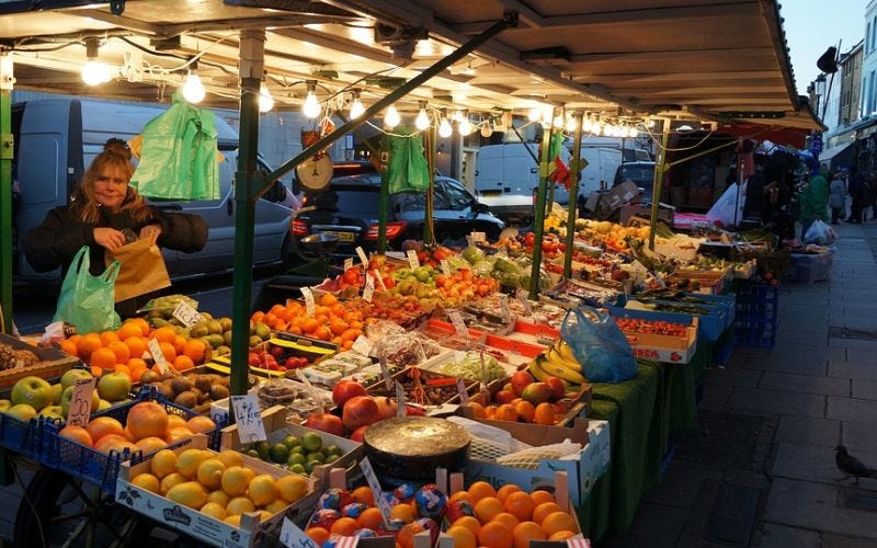 Fruitkraam op een markt met zelfstandig ondernemer die werkt als groenteboer.