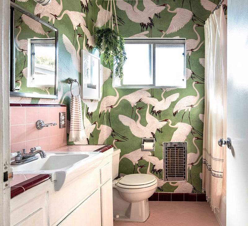 A pink bathroom with custom bird wallpaper.
