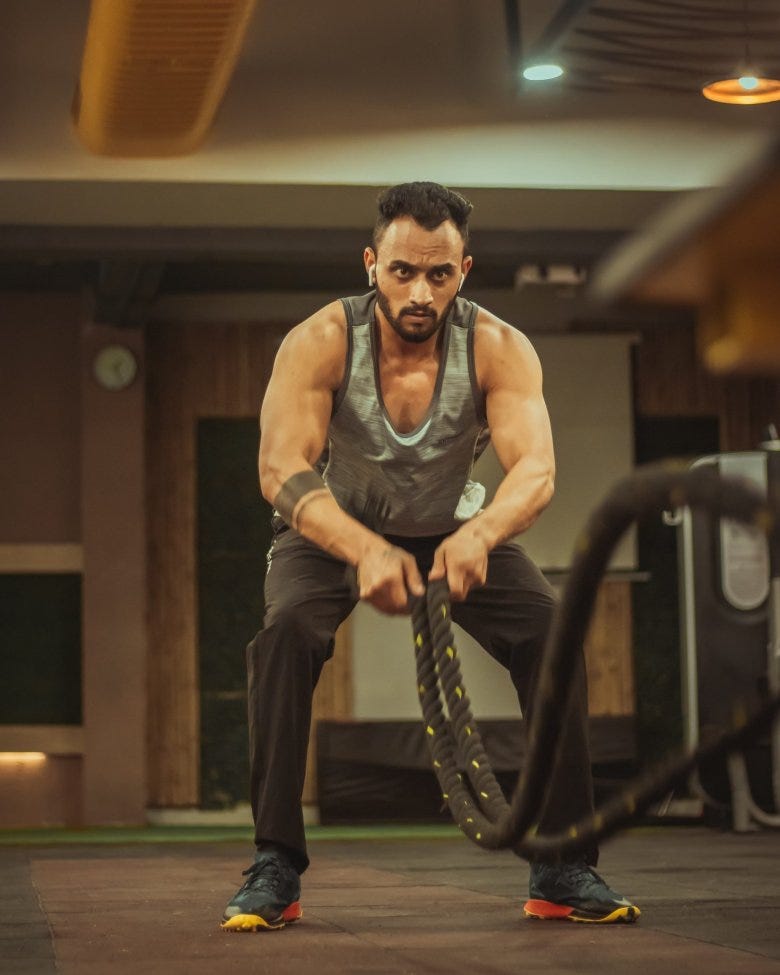 A man engaged in an intense battle rope session.