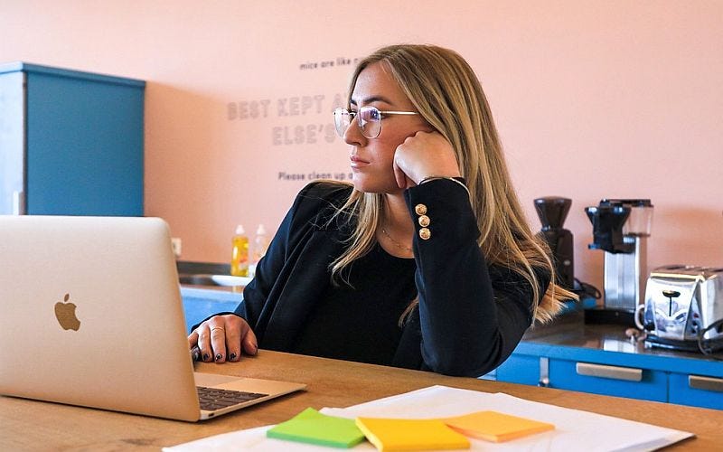 Vrouw achter laptop die nadenkt over het ondernemerschap