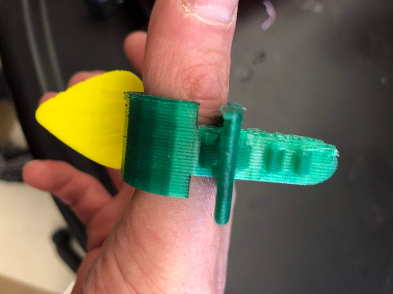 Students designed and 3D printed a guitar pick holder which can be put around the finger of a guitar player and incrementally adjusted for size.