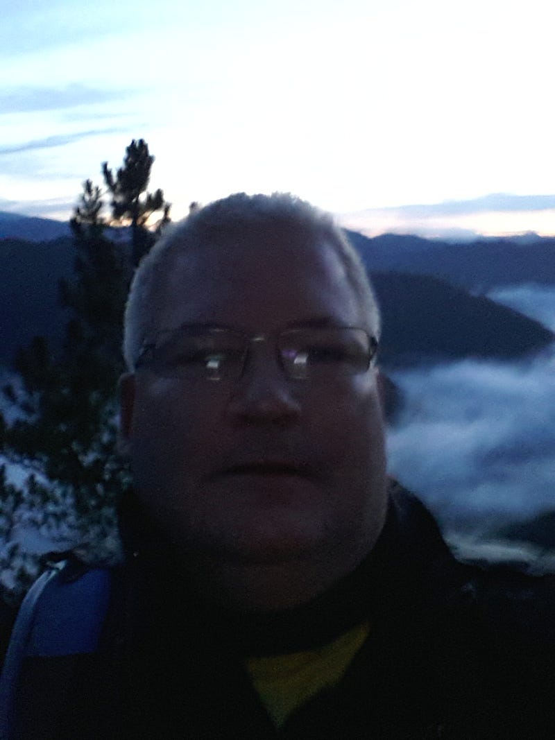 Selfie of me as a headshot in front of the cloud inversion.