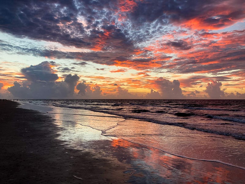 Silver lining: a vibrant sunrise over the beach with storm clouds on the horizon