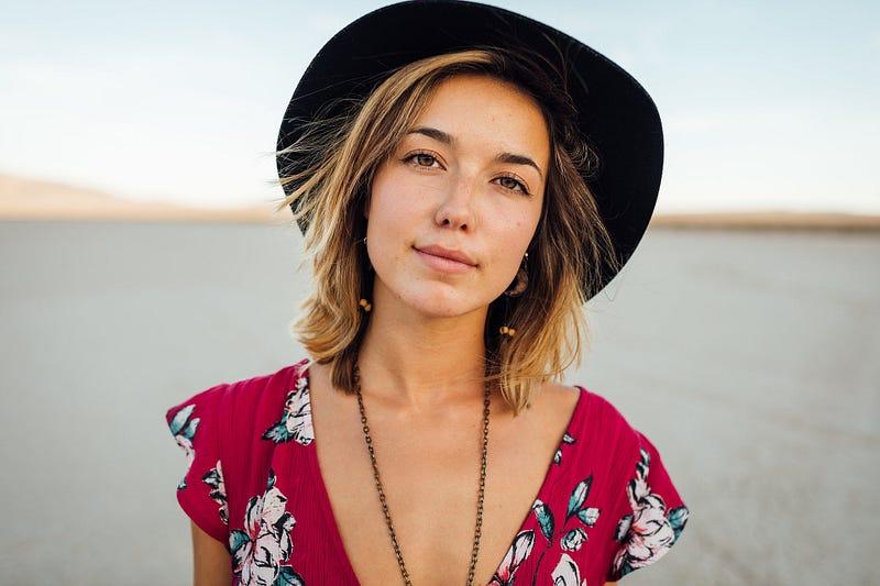 A smiling woman wearing a hat.