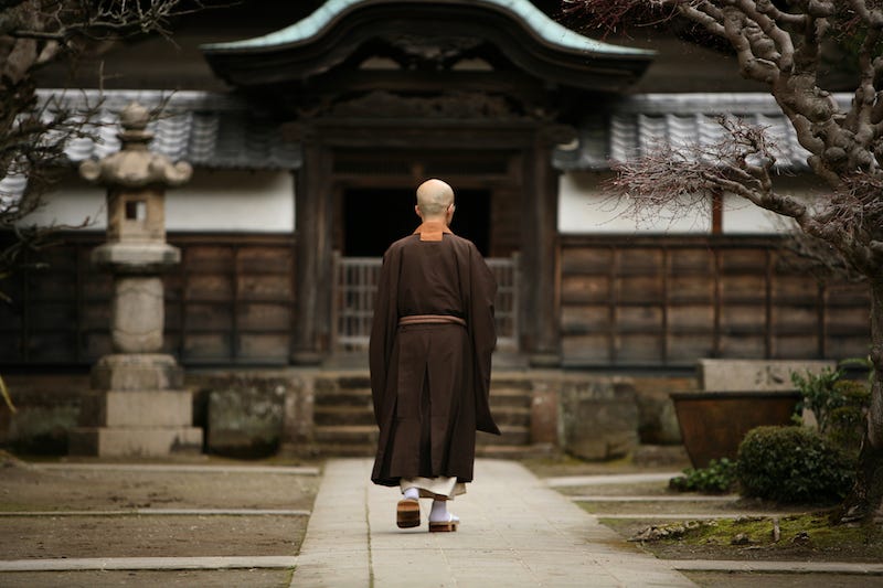 A Buddhist monk walks towards the gate of one of Kamakura’s many temples