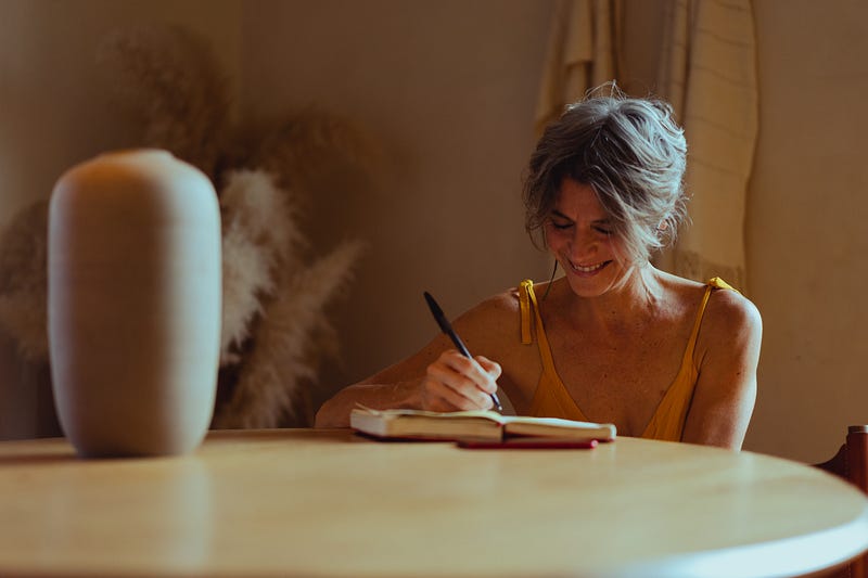 A women laughing while writing.