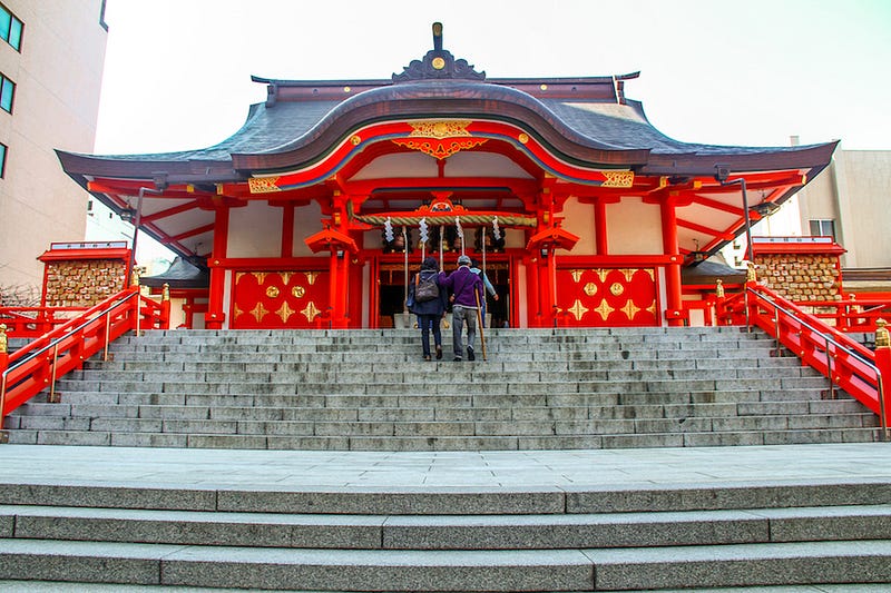A couple ascends the stairs at Shinjuku’s Hanazono Shrine