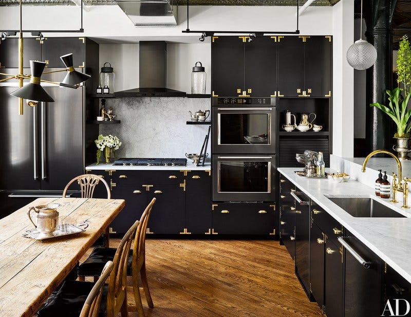 black cabinetry and gold wood floor kitchen by Ken Fulk