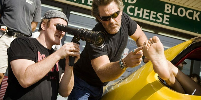 Quentin Tarantino directing, pointing lens at a bare foot hanging out a car