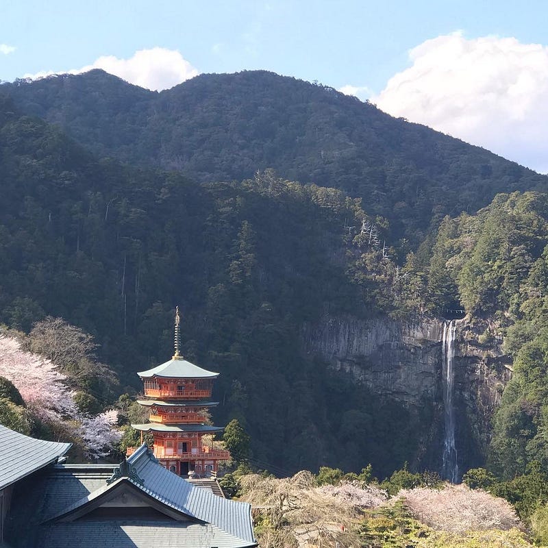 Nachi Waterfall streams down behind a 3-story orange pagoda.