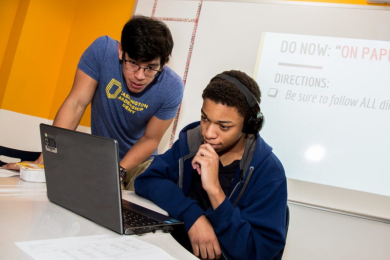 A teacher and student look at a computer at Washington Leadership Academy in Washington, D.C.