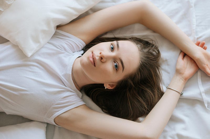 A woman lying in the bed, looking at the camera