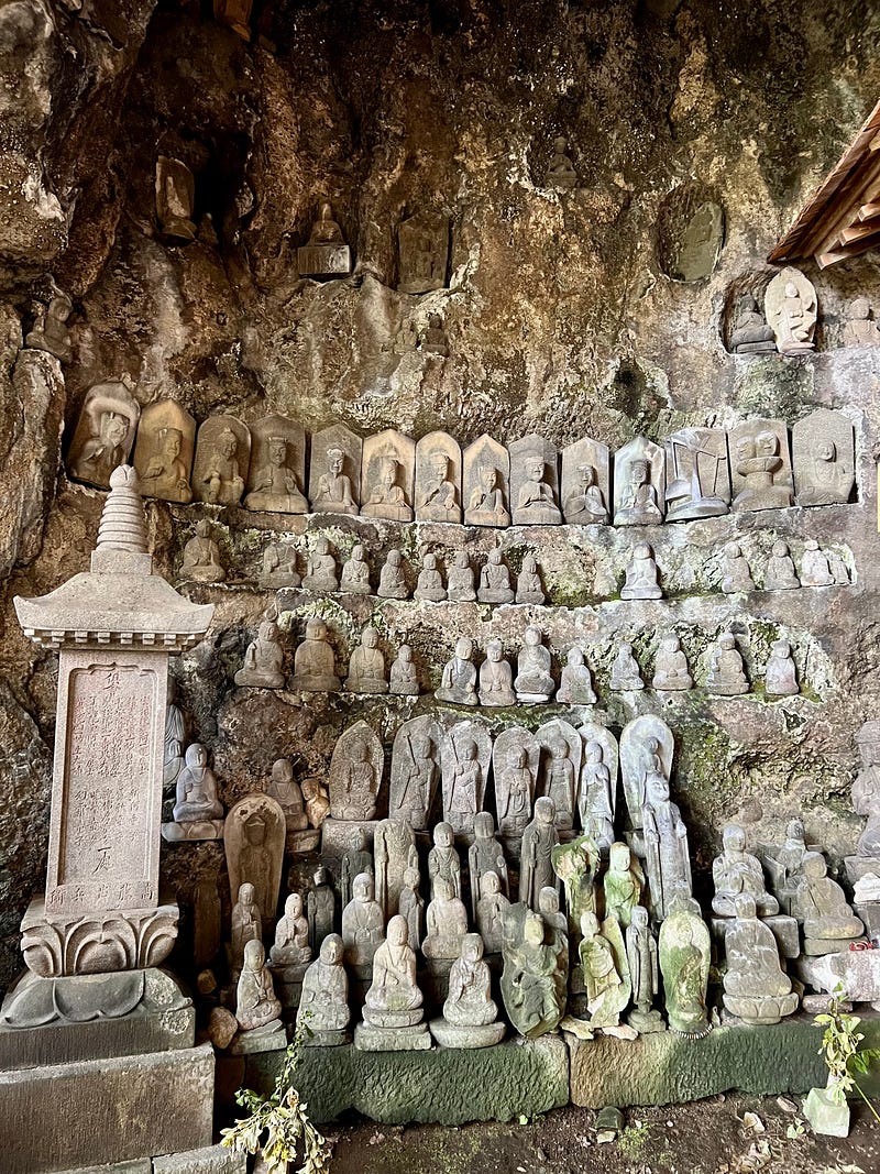 Cave wall covered with rows of Buddhist statues, Sado Island.