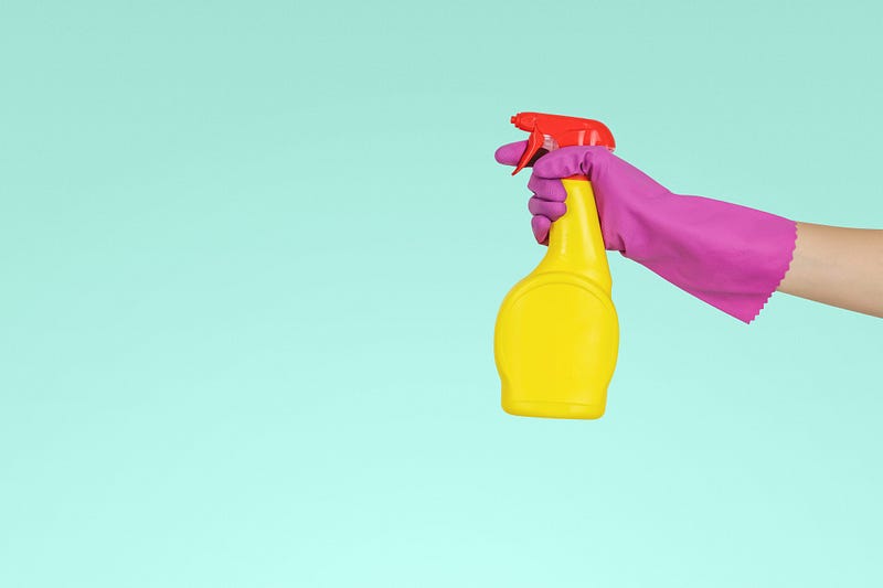 A gloved hand holding a spray bottle.