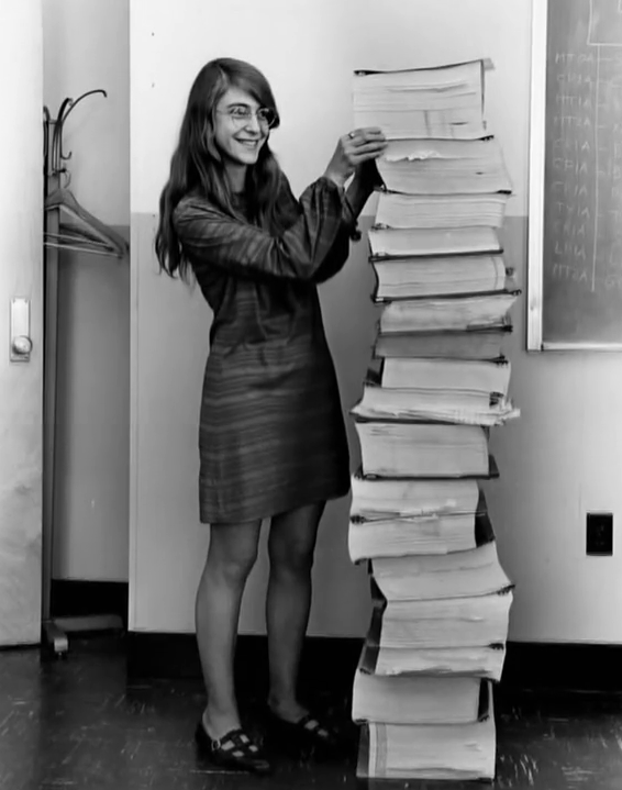 Hamilton stands next to a stack of Apollo Guidance Computer source code.