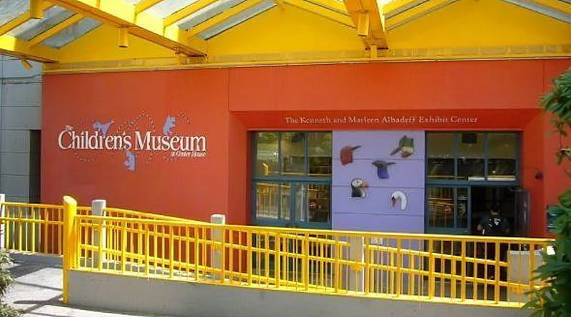 outside of Seattle Children’s Museum building with logo visible on red wall