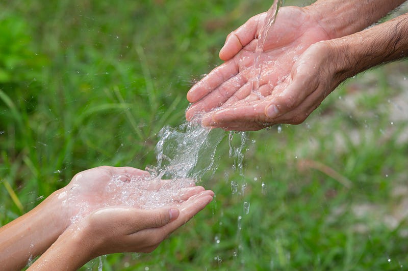manos usando agua que cae sobre ellas