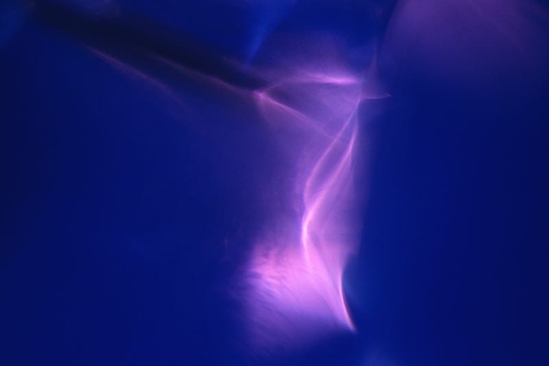 Abstract photograph of swirling purple light on blue background, for healing