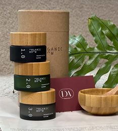 A bamboo bowl and wooden spoon next to two jars of organic skin care, showcasing natural eyebrows and eco-friendly products.