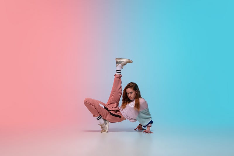Girl dancing hip-hop in stylish clothes on gradient background at dance hall in neon light