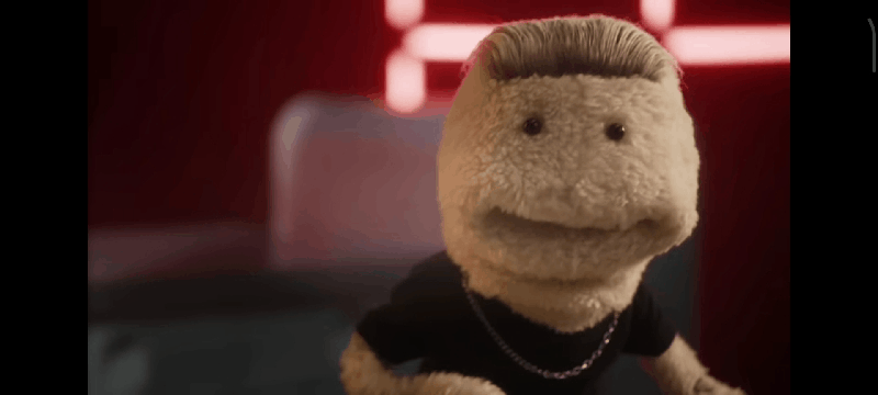 A GIF of the camera panning out to show that the puppet is spreading Marmite on toast