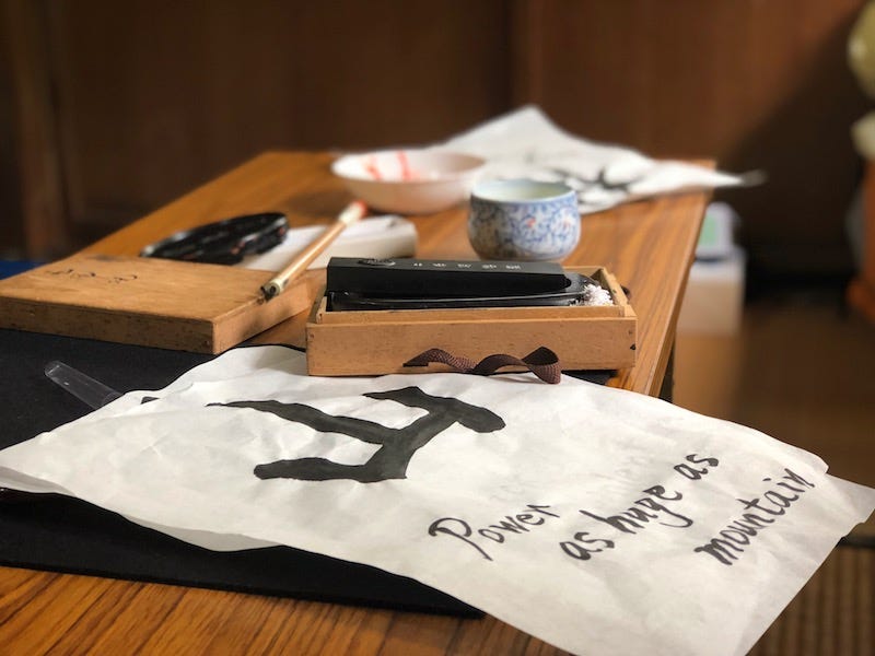 Tour paricipants practice writing the kanji for Takeda Shingen’s slogan, fu-rin-ka-zan