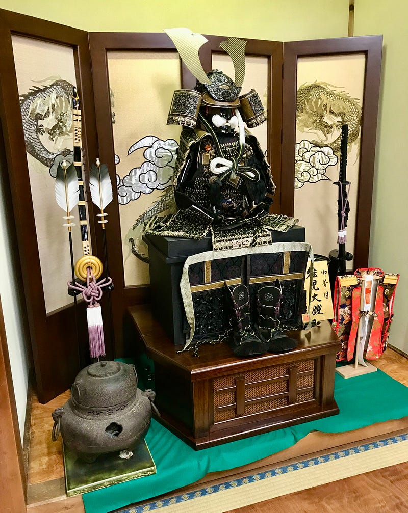Samurai armor, arrows, and sword in front of a folding screen are decorations for Children's Day.