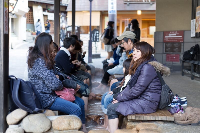 People bath their feet at an ashiyu foot bath in Kobe’s Arima Onsen
