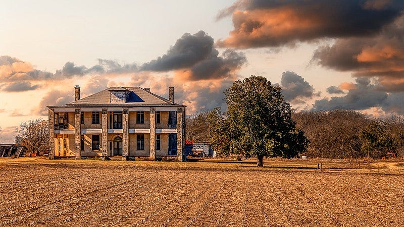 Grey clouds over the iconic Texas Chainsaw house, a lone old house in the middle of a field of dead grass