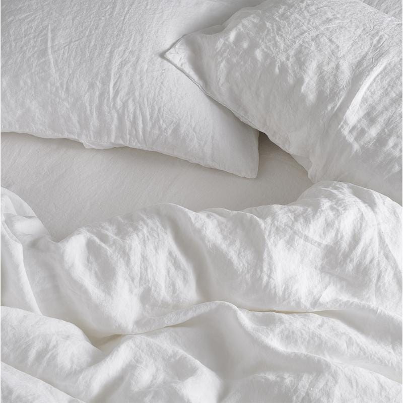 Relaxed white linen bedding casually arranged on the bed. To shop the linen click on the image