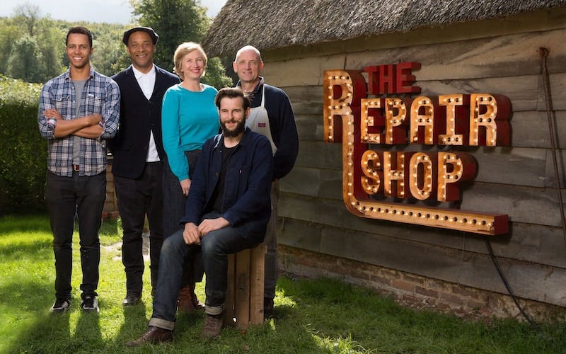 Five expert cast members from The Repair Shop standing in front of a barn