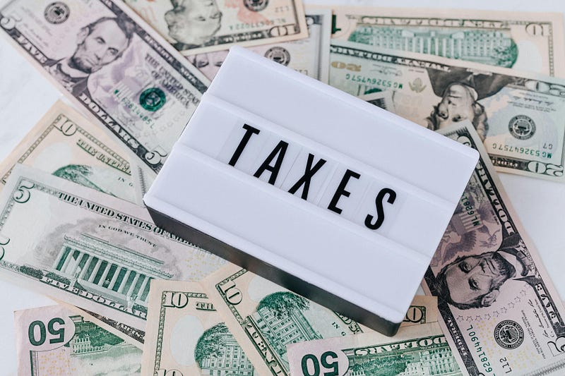 Quote Board on top of Cash Bills with the words “Taxes”