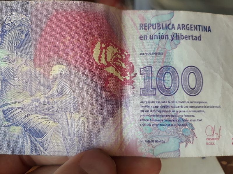 A photo that I took from a note of 100 Argentinian pesos. It is the equivalent of 0.42 US dollar.