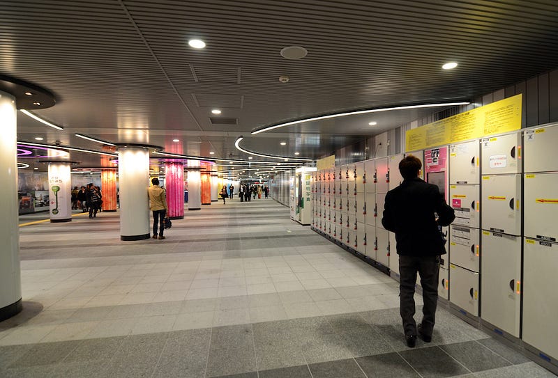 A man walks by a bunch of coin lockers at a major Japanese train station