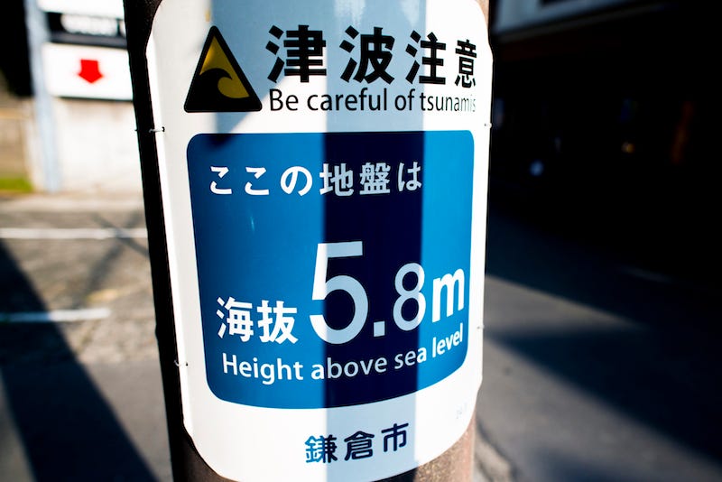 A warning on a sign post in Japan to be careful of tsunami