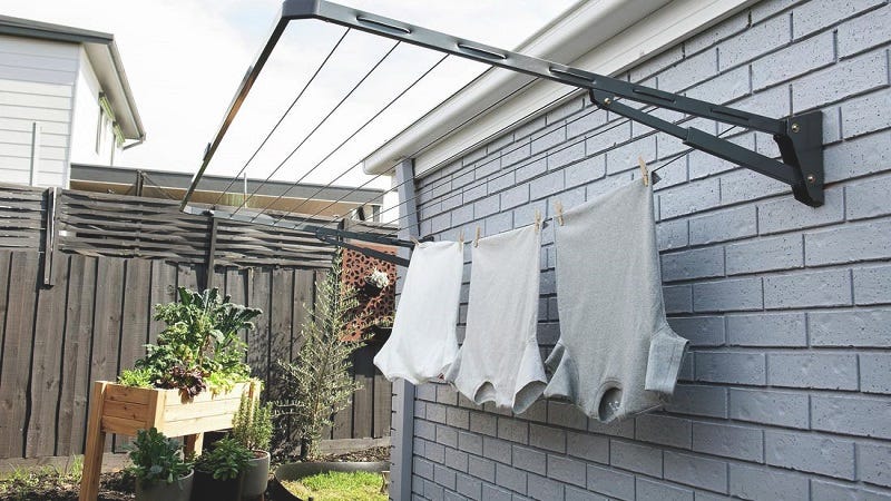 Foldable wall-mounted clothesline in backyard