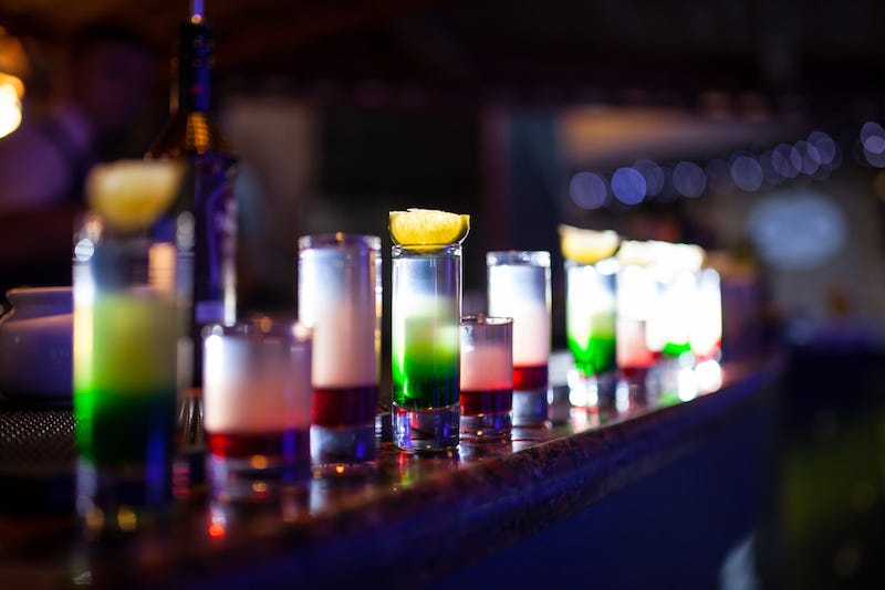 A patron tips a bartender in Japan for a number of shots even though it isn’t needed