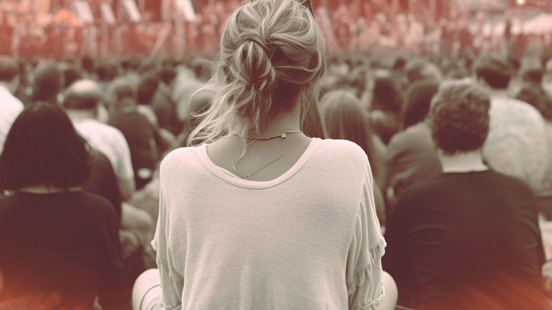 Girl seated in crowd at a music festival practicing mindfulness