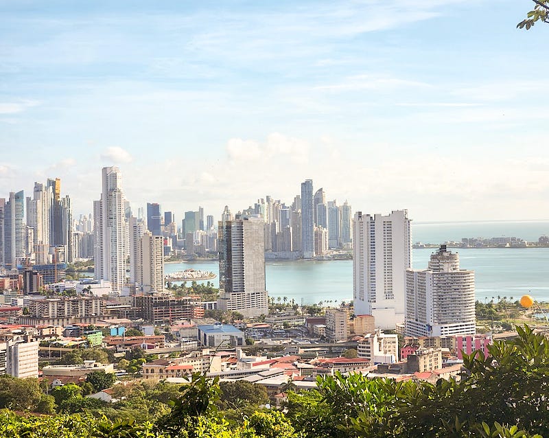 A cityscape of many skyscrapers along an ocean bay. Taken from above.
