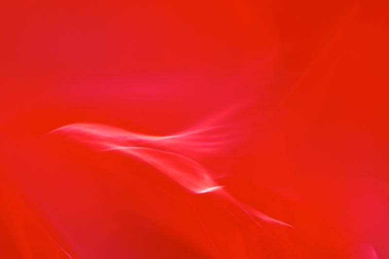 Vivid red abstract photograph with swirl of white, taken for healing by medical doctor