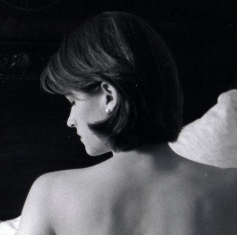 Black and white image of a young woman’s bare shoulders from behind