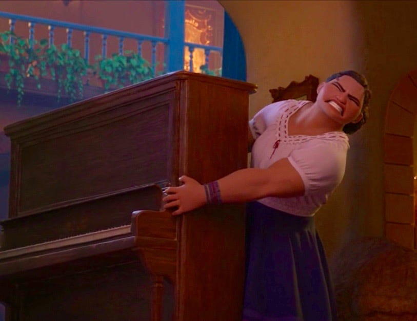 Luisa, from the Disney film ENCANTO, struggling to move a piano.