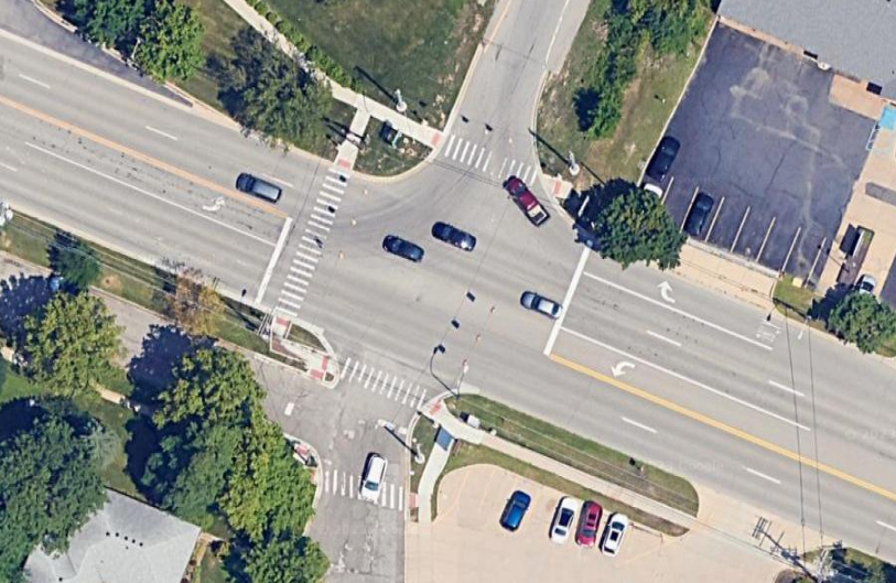 A google maps image of the intersection directly outside my neighborhood. The interestion has many lanes on all 4 side and the speed limit is 45 mph. There are only cross walks on 3 of the 4 sides, making it difficult to cross.