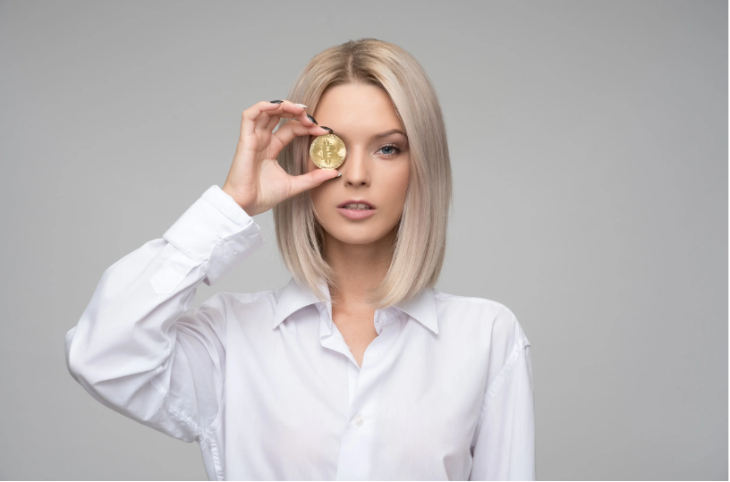 A lady with a coin looking through her eyes.