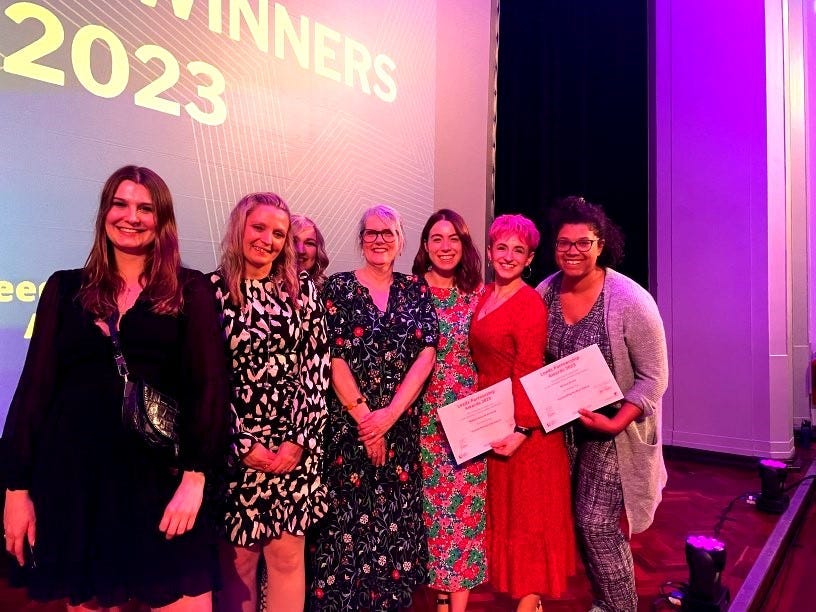 An image of Zofia Wilk, Emma Taylor, Kim Crossley, Jo Huett, Laura Conroy, Lauren Huxley and Bryony Brown on stage holding their Partnership Awards certificates.