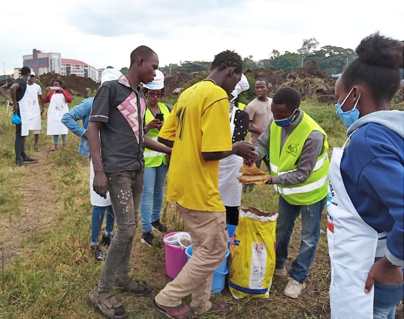 Young men line up to collect prepared food.