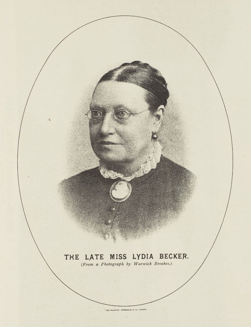 Head and shoulders photographic portrait of a Victorian woman wearing round glasses and a cameo brooch.