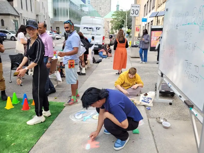 Students decorating the sidewalk on Bond Street with chalk.